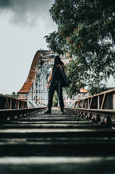 白天站在桥上的穿黑夹克的女人